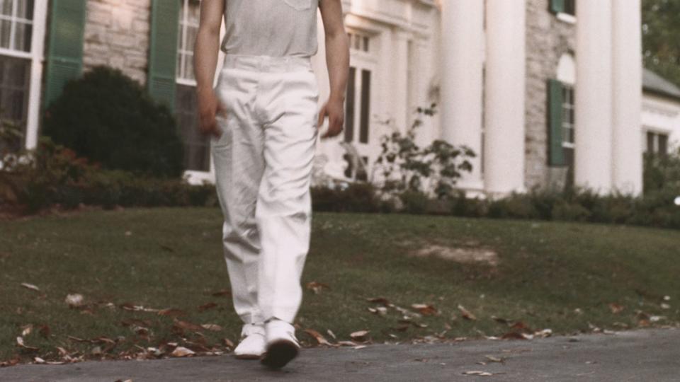 elvis presley walking on front of his graceland home