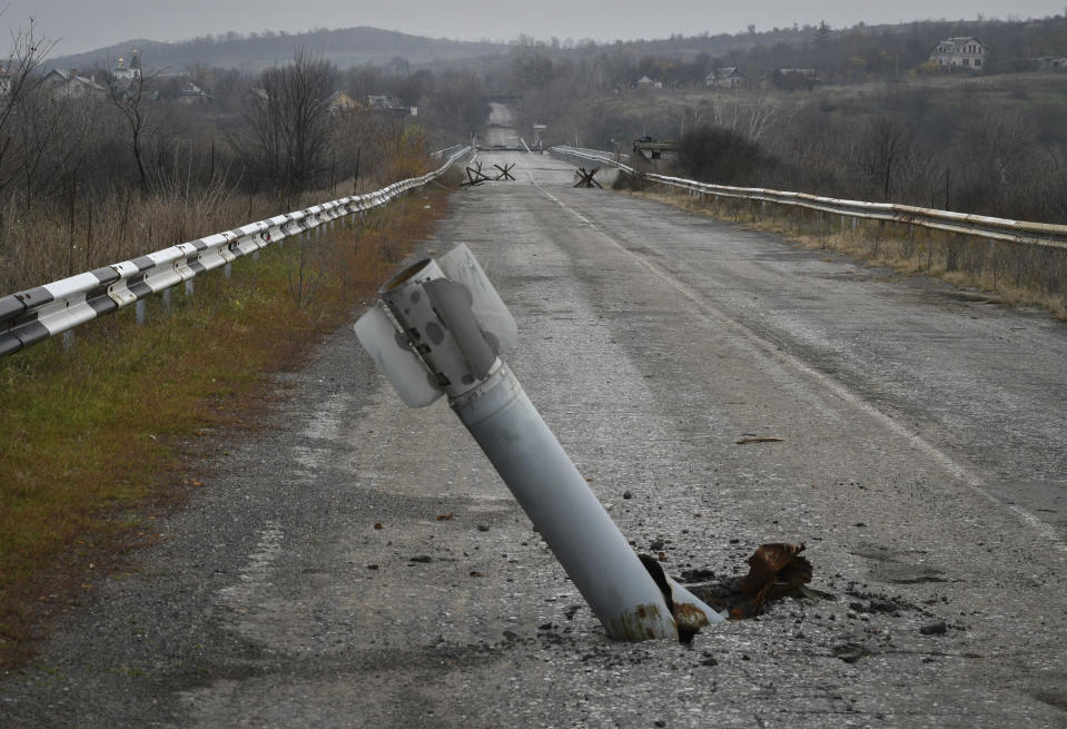 A tail of a multiple rocket sticks out of the ground near the recently recaptured village of Zakitne, Ukraine, Wednesday, Nov. 9, 2022. Villages and towns in Ukraine saw more heavy fighting and shelling Wednesday as Ukrainian and Russian forces strained to advance on different fronts after more than 8 1/2 months of war. At least nine civilians were killed and 24 others were wounded in 24 hours, the Ukrainian president's office said. (AP Photo/Andriy Andriyenko)