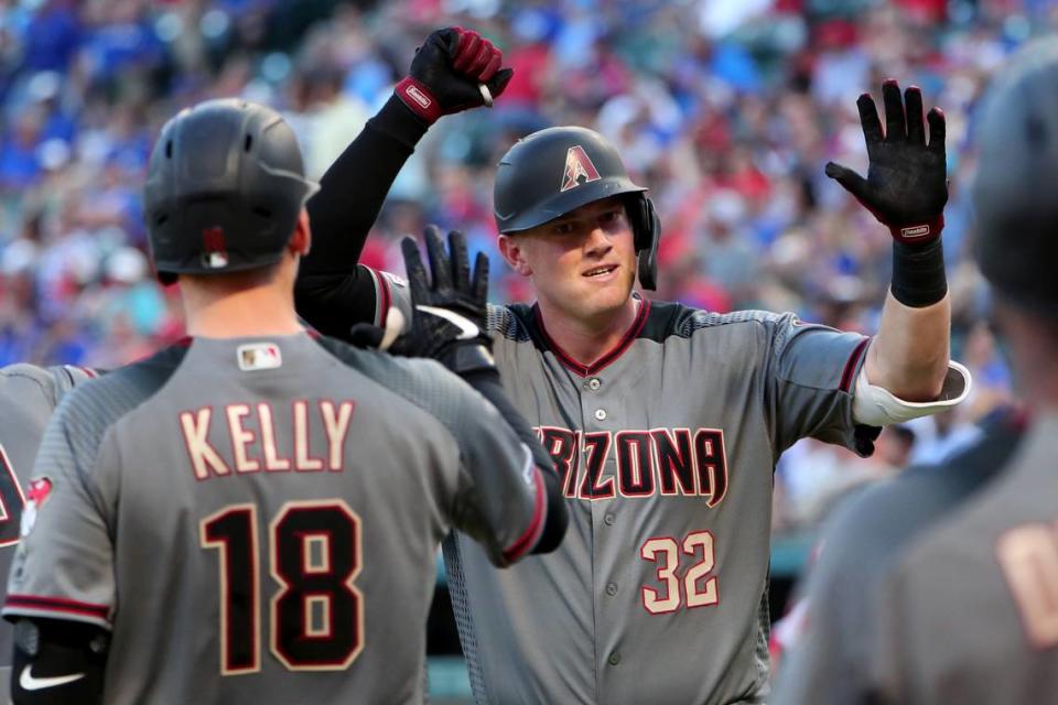 Former TCU star Kevin Cron, of the Arizona Diamondbacks, celebrates with Carson Kelly, left, after Cron hit a three-run home run against the Texas Rangers in the second inning at Globe Life Park Wednesday night.