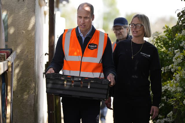 <p>Alastair Grant-WPA Pool/Getty Images</p> Prince William carries a tray while walking with Claire Hopkins, operations director of Surplus to Supper, on April 18, 2024.