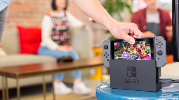 A person reaching for a Nintendo Switch.