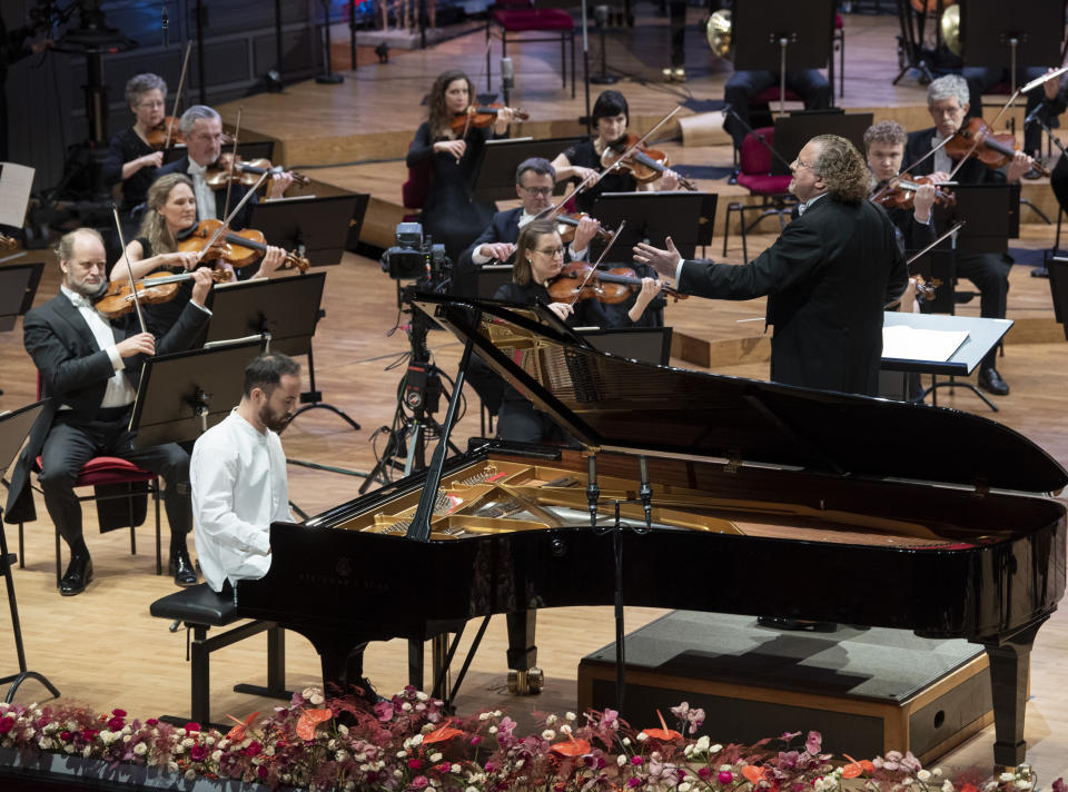 FILE - Russian-German pianist Igor Levit and French conductor Stephane Deneve with the Royal Stockholm Philharmonic Orchestra perform Beethoven's Piano Concerto No. 5 (Emperor Concerto) during the televised Nobel Prize Concert 2020 at the Stockholm Concert Hall, in Stockholm, Sweden, on Dec. 8, 2020. Levit will perform Shostakovich’s 24 “Preludes and Fugues" at Carnegie Hall on Tuesday night, part of a quick U.S. tour that takes him to the Kennedy Center in Washington, D.C., on Thursday and Clayton State University in Morrow, Georgia, on Sunday. (Fredrik Sandberg/TT News Agency via AP, File)