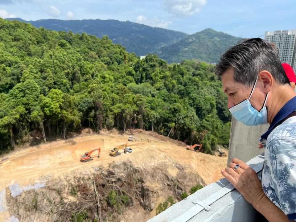 Richard Lim indicates the highway project on the slope that is right next to the Kingfisher Series condominium. 