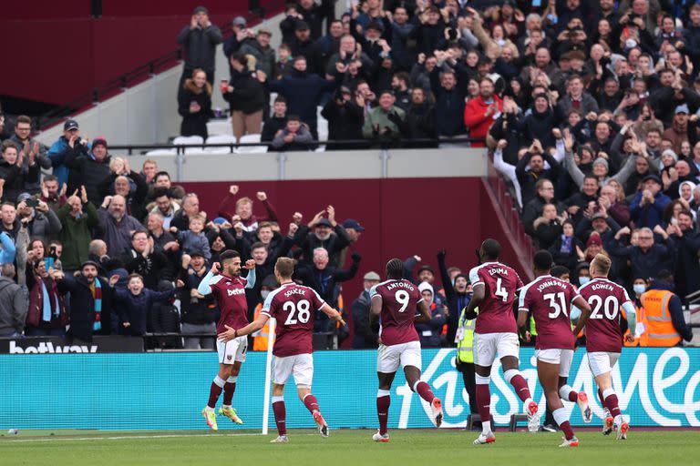 Manuel Lanzini del West Ham United celebra con sus compañeros de equipo después de anotar el primer gol de su equipo desde el punto de penalti durante el partido de la Premier League entre West Ham United y Chelsea.