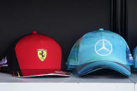 Team Ferrari and Mercedes caps are shown for sale at a shop at the Formula One Miami Grand Prix auto race at Miami International Autodrome, Sunday, May 8, 2022, in Miami Gardens, Fla. (AP Photo/Wilfredo Lee)