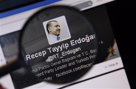 An image of Turkish Prime Minister Tayyip Erdogan on a twitter account is pictured through a magnifying glass in this illustration picture taken in Istanbul March 21, 2014. REUTERS/Murad Sezer