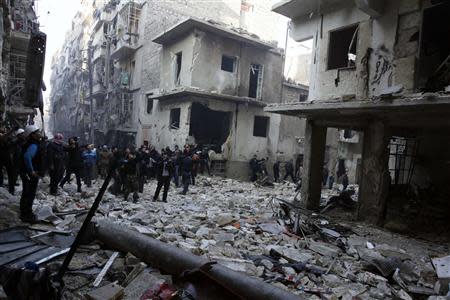 Residents inspect a damaged site after what activists said was an air strike from forces loyal to Syria's President Bashar al-Assad in Takeek Al-Bab area of Aleppo