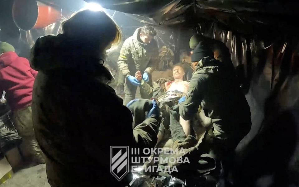 A Ukrainian soldier receives medical attention  after fighting in Avdiivka