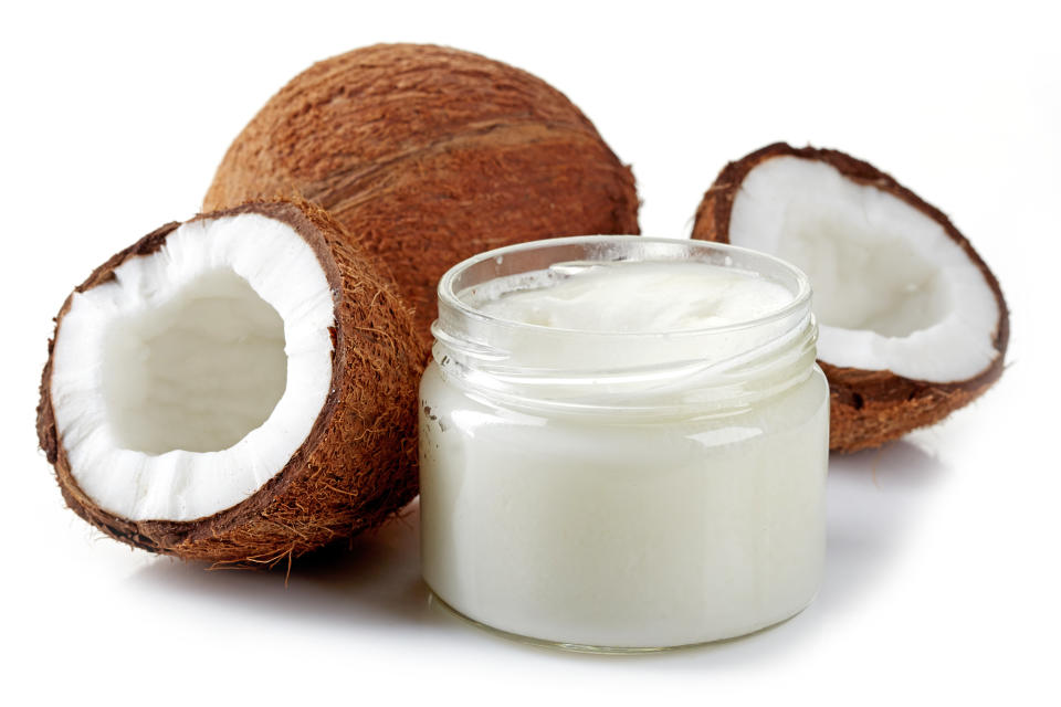 jar of coconut oil and fresh coconuts isolated on white