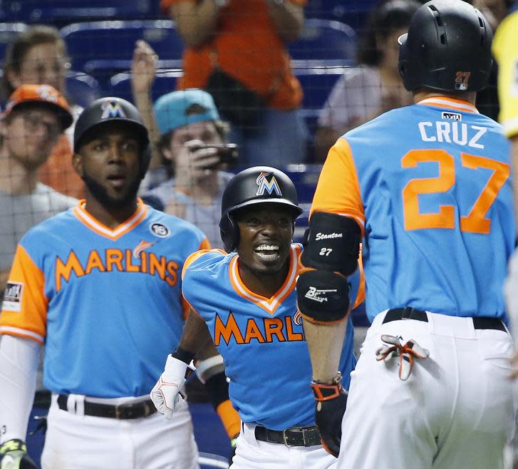 Giancarlo Stanton is congratulated by Dee Gordon (center) and Marcell Ozuna (left) after connecting for his 48th home run of the season. (AP)