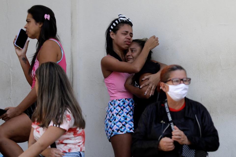 Relatives wait outside hospital for the arrival of people injured (AP)