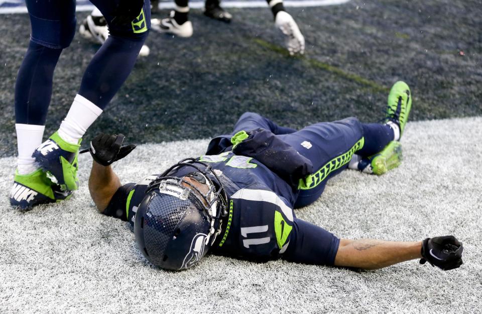 Seattle Seahawks wide receiver Percy Harvin lies on the ground after being injured during the second quarter of an NFC divisional playoff NFL football game against the New Orleans Saints in Seattle, Saturday, Jan. 11, 2014. (AP Photo/Ted S. Warren)