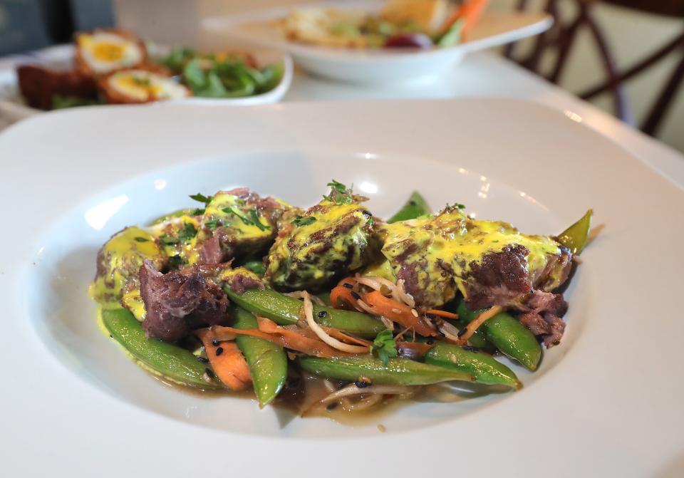 The Revival Room features Braised Pork Cheek with sauteed Asian sesame bean salad, turmeric cream sauce and brined sprouts on the menu on Friday, Nov. 10, 2023, in Hudson, Ohio. [Phil Masturzo/ Beacon Journal]