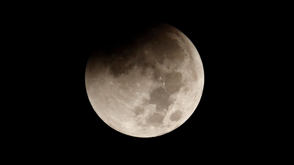 The full beaver moon begins to pass through the Earth's shadow during a total lunar eclipse in November in New York. On Saturday, a partial lunar eclipse will occur for those on the night side of Earth from 3:34 p.m. to 4:52 p.m. ET. - Gary Hershorn/Corbis News/Getty Images