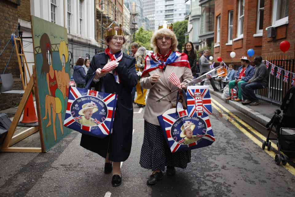 Two women attend a public street party in Castle Lane in central London, Sunday June 5, 2022, on the last of four days of celebrations to mark the Platinum Jubilee. Street parties are set to be held across the country in what is being called The Big Jubilee Lunch. The events over a long holiday weekend in the U.K. have celebrated Queen Elizabeth II's 70 years of service. (AP Photo/David Cliff)