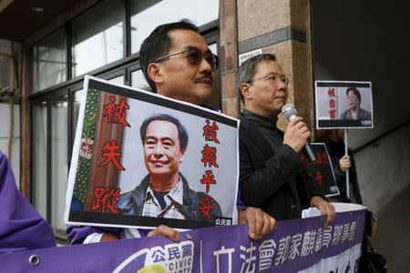 Members from the pro-democracy Civic Party carry a portrait of Lee Bo (L) and Gui Minhai before they protest outside Chinese Liaison Office in Hong Kong, China January 19, 2016. REUTERS/Bobby Yip