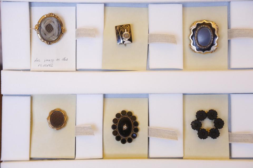 This Oct. 29, 2013, photo taken in Evanston, Ill., shows death pins at the Charles Deering McCormick Library of Special Collections. The broach like pins worn by women after the death of a loved one, are but a few of the artifacts from the “Death Collection” - an archive of death-related oddities once owned by horror novelist and screenwriter Michael McEachern McDowell that were acquired by the Library and are now housed on the campus of Northwestern University. The pin in the upper left contains a lock of woven hair from the deceased. (AP Photo/M. Spencer Green)