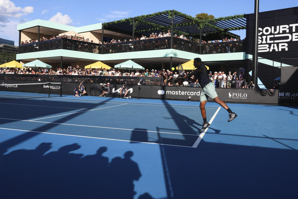 Fans watch France's Gael Monfils first round match from a bar overlooking court 6 at the Australian Open tennis championships at Melbourne Park, Melbourne, Australia, Monday, Jan. 15, 2024. There's a certainly a buzz around the bar that overlooks Court 6 and gives Australians Open fans a shady place to have a cool drink on a hot day, which is something of a national tradition. It's popular with fans but the music and constant movement adjacent to a Grand Slam tennis court is dividing opinion among players.(AP Photo/Asanka Brendon Ratnayake)