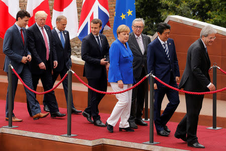 From L-R, Canadian Prime Minister Justin Trudeau, U.S. President Donald Trump, European Council President Donald Tusk, French President Emmanuel Macron, German Chancellor Angela Merkel, European Commission President Jean-Claude Juncker, Japanese Prime Minister Shinzo Abe and Italian Prime Minister Paolo Gentiloni walk after a family photo during the G7 Summit in Taormina, Sicily, Italy, May 26, 2017. REUTERS/Jonathan Ernst