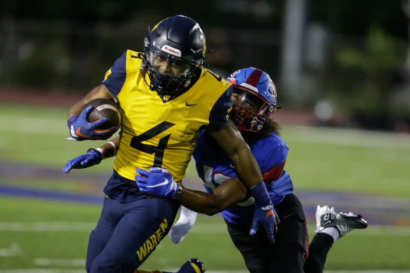 GARDENA, CA - SEPTEMBER 09: Downey Warren running back Romeo Clark (4) runs as Noa Keohuloa line backer of Gardena Serra attempts a tackle on Friday, Sept. 9, 2022 in Gardena, CA. (Jason Armond / Los Angeles Times)