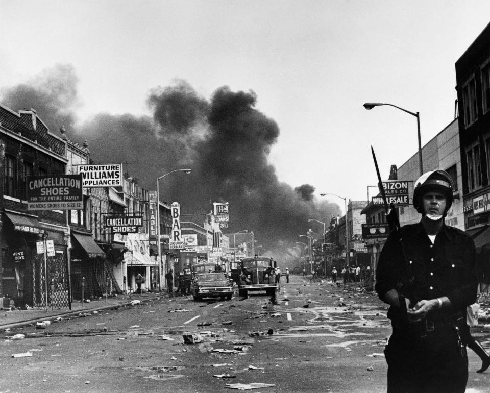 A policeman stands guard in a Detroit street on July 25, 1967, as buildings are burning during riots that erupted following a police operation. (Photo: Getty Images)