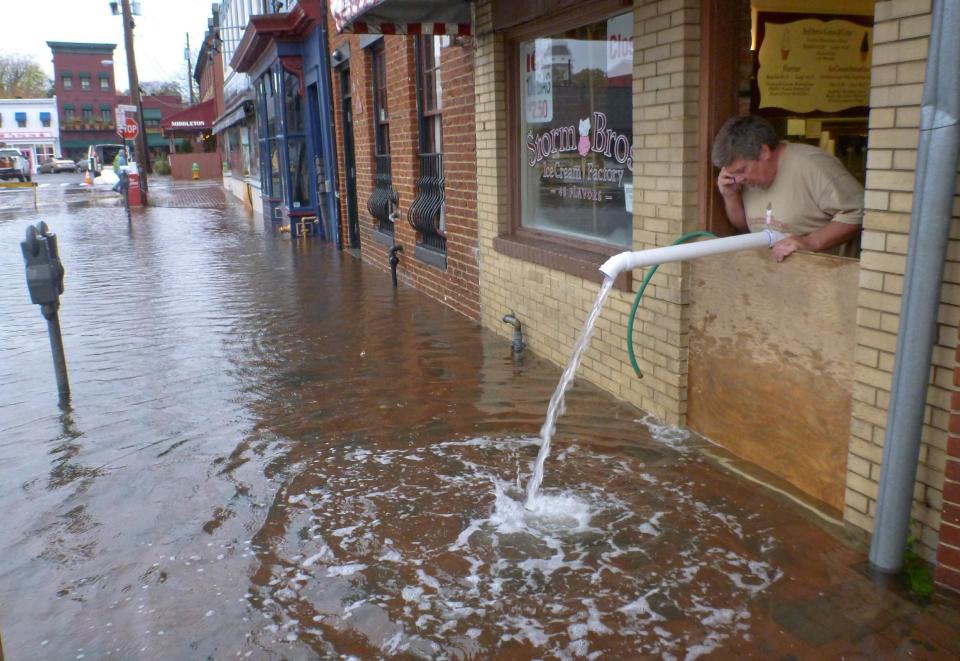 Sveinn Storm pumps water out of his flooded Storm Bros. Ice Cream Factory store in downtown Annapolis, Md. on Tuesday, Oct. 30, 2012, in the aftermath of Hurricane Sandy. High tide swept over the banks of the city dock, flooding lower Annapolis stores. (AP Photo/Blake Sell)