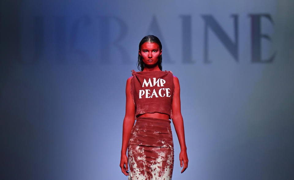 Bei der Berliner Modewoche trägt ein Model bei der Show des ukrainischen Designers Jean Gritsfeldt ein blutig-rotes Outfit mit der Aufschrift 