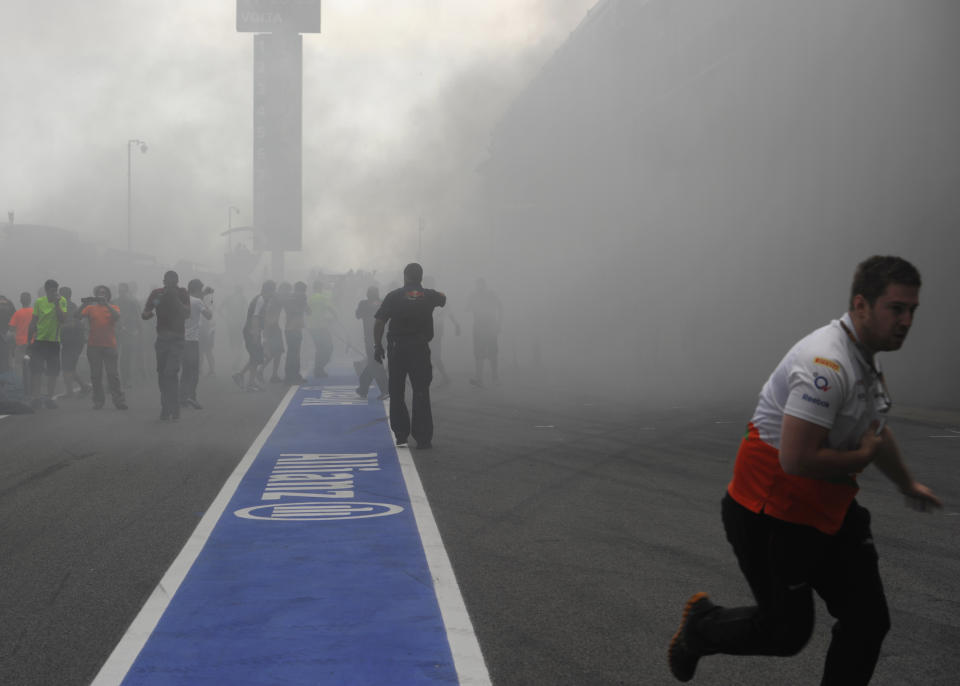 Racing team crews run to help extinguish a fire in the Williams racing pit stand at the Circuit de Catalunya on May , 2012 in Montmelo on the outskirts of Barcelona after the Spanish Formula One Grand Prix.   AFP PHOTO / DIMITAR DILKOFFDIMITAR DILKOFF/AFP/GettyImages