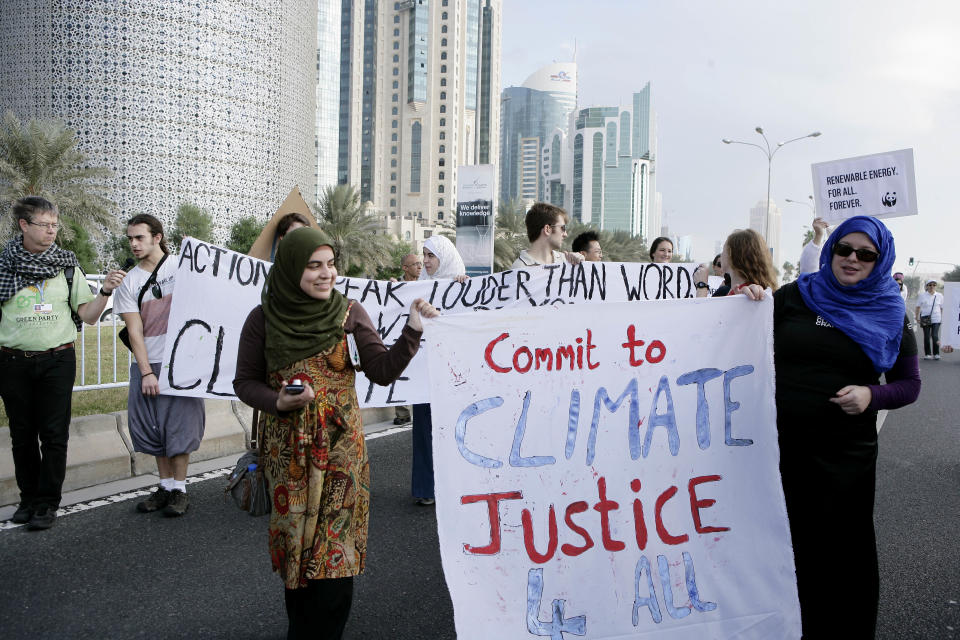 Qatari Women activists holding a banner reading "commit to climate justice 4 all " as they march with local and international activists march to demand urgent action to address climate change at the U.N. climate talks in Doha, Qatar, Saturday , Dec. 1, 2012. (AP Photo/Osama Faisal)