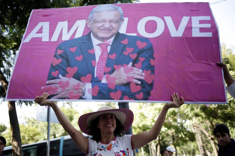 A supporter of Mexican President Andres Manuel Lopez Obrador holds up a sign after she attended an event for the anniversary of the first year in the office of Mexico's President Andres Manuel Lopez Obrador in Mexico City