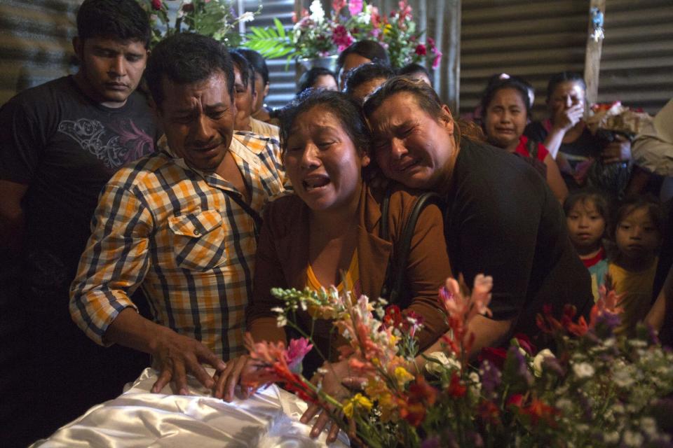 En esta imagen del viernes 10 de marzo de 2017, Marta Lidia García, en el centro, llora durante el velorio de su hija de 17 años Siona Hernández, que murió en un incendio en un albergue juvenil, en Ciudad Peronia, Guatemala. (AP Foto/Moisés Castillo)