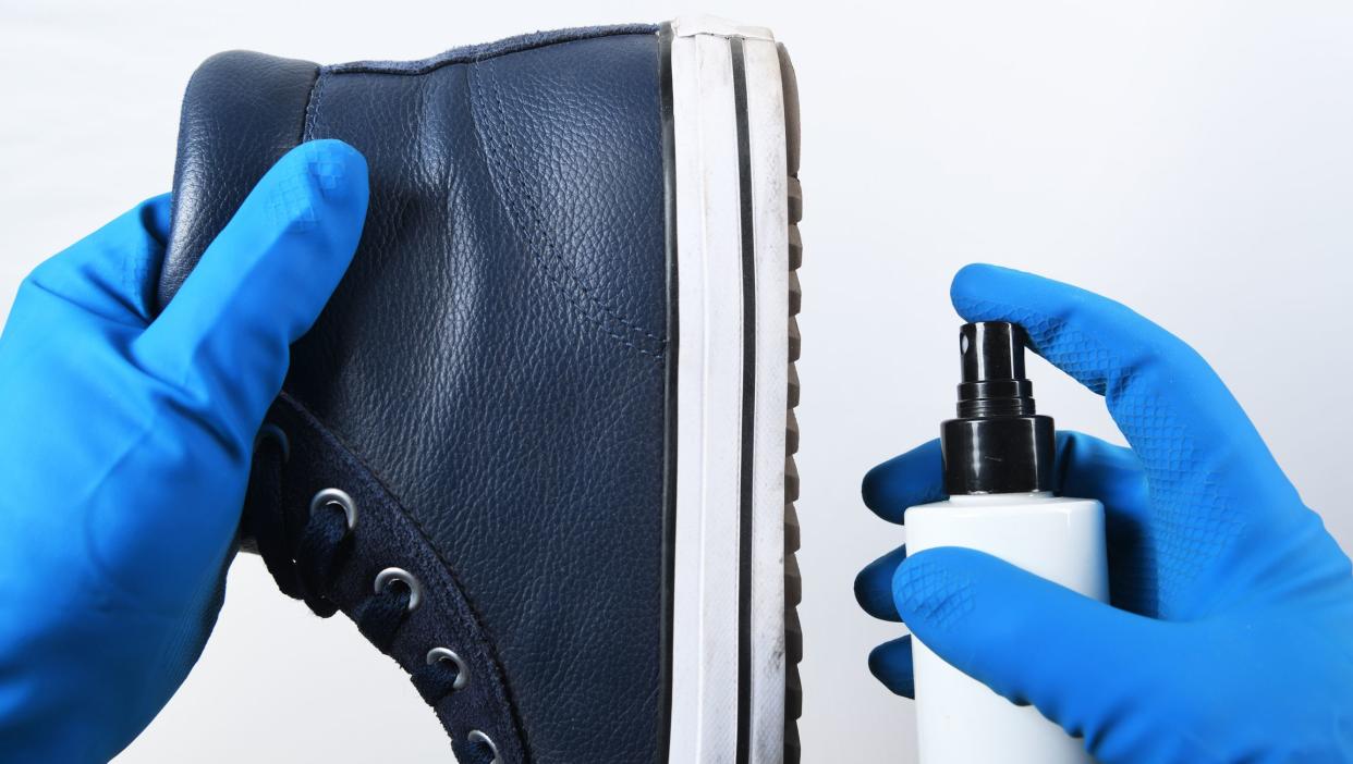 Man disinfecting his shoes.Preventive measures against Covid-19 infection. A man cleans his shoes.