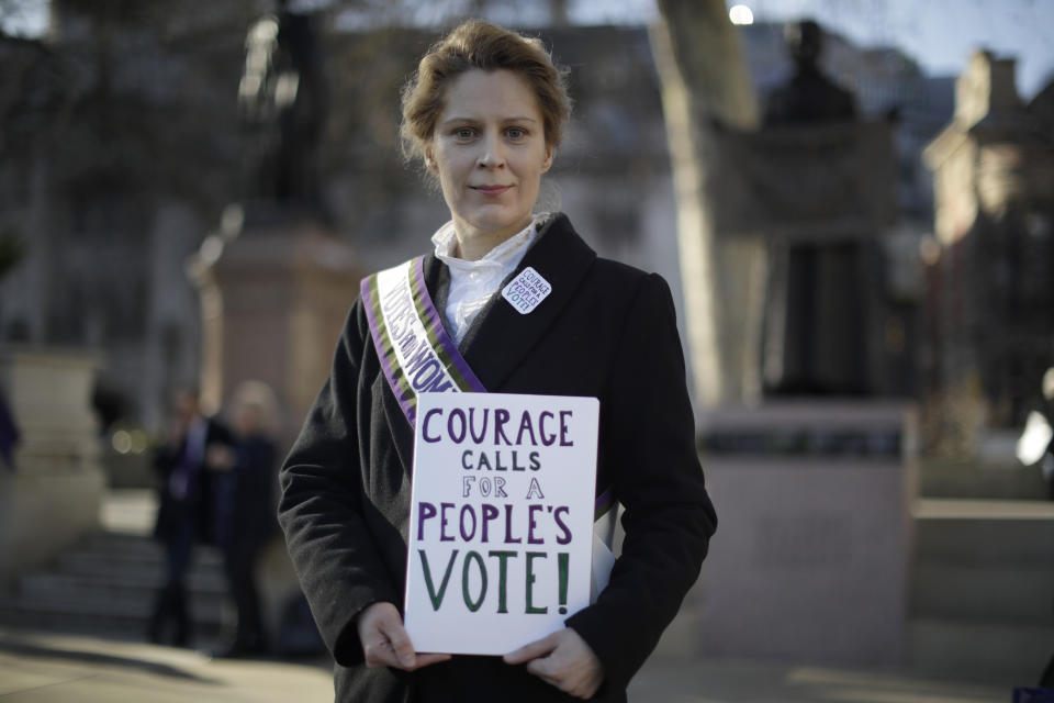 Remain in the European Union supporter Kate Willoughby, from Yorkshire and dressed as early 20th century suffragette Emily Davison, poses for photographs backdropped by a statue at right of suffragist Millicent Fawcett on Parliament Square opposite the Houses of Parliament in London, Thursday, Feb. 14, 2019. Kate believes putting another referendum back to the people of Britain that is free and fair, as much has changed since the 2016 referendum, would be the best way forward. With Brexit only days away, it is in the grounds outside parliament that the true believers gather each day to try to influence lawmakers, call attention to their cause, and bring new supporters into the fold.(AP Photo/Matt Dunham)