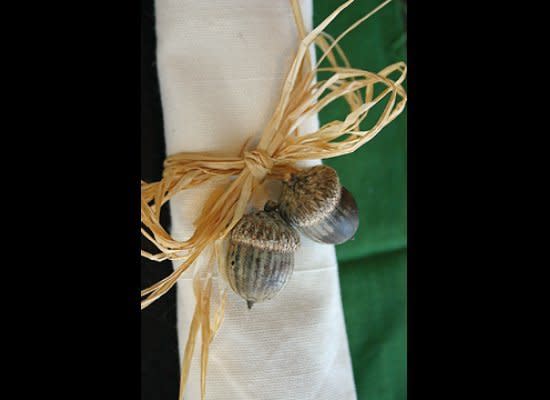 All you have to do to make these great napkin rings is hot glue gun acorns to <a href="http://www.ziggos.com/kraft-raffia-60-spool-f-9460.html" target="_hplink">raffia</a> and then tie a bow!     Photo by <a href="http://www.nofussfabulous.com/?p=1031" target="_hplink">Loralee Lewis</a> 