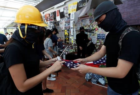 Anti-government protesters fold a US flag after a rally at the University of Hong Kong