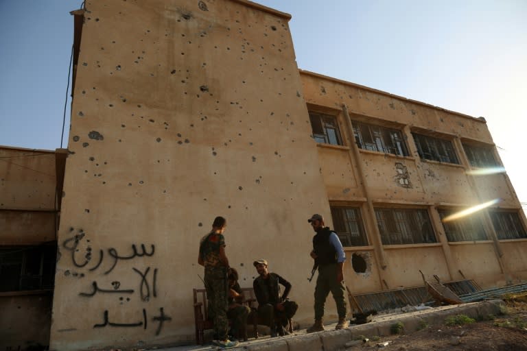 Kurdish fighters belonging to the police force -- the Asayesh -- and the People's Protection Units (YPG) stand in the northeastern Syrian city of Hasakeh on August 23, 2016, after they agreed to a truce with regime forces