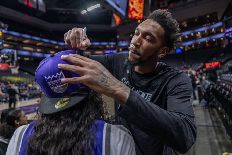 Sacramento Kings guard Malik Monk signs a hat for a fan before a game in February.