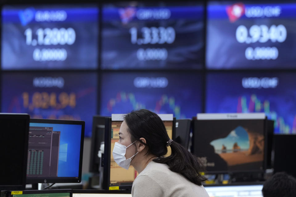 A currency trader watches monitors at the foreign exchange dealing room of the KEB Hana Bank headquarters in Seoul, South Korea, Thursday, Nov. 25, 2021. Asian stock markets fell Thursday after Federal Reserve officials indicated they were ready to raise interest rates sooner than expected if needed to cool inflation.(AP Photo/Ahn Young-joon)