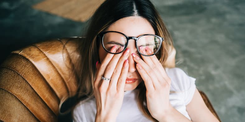 young woman rubs her eyes