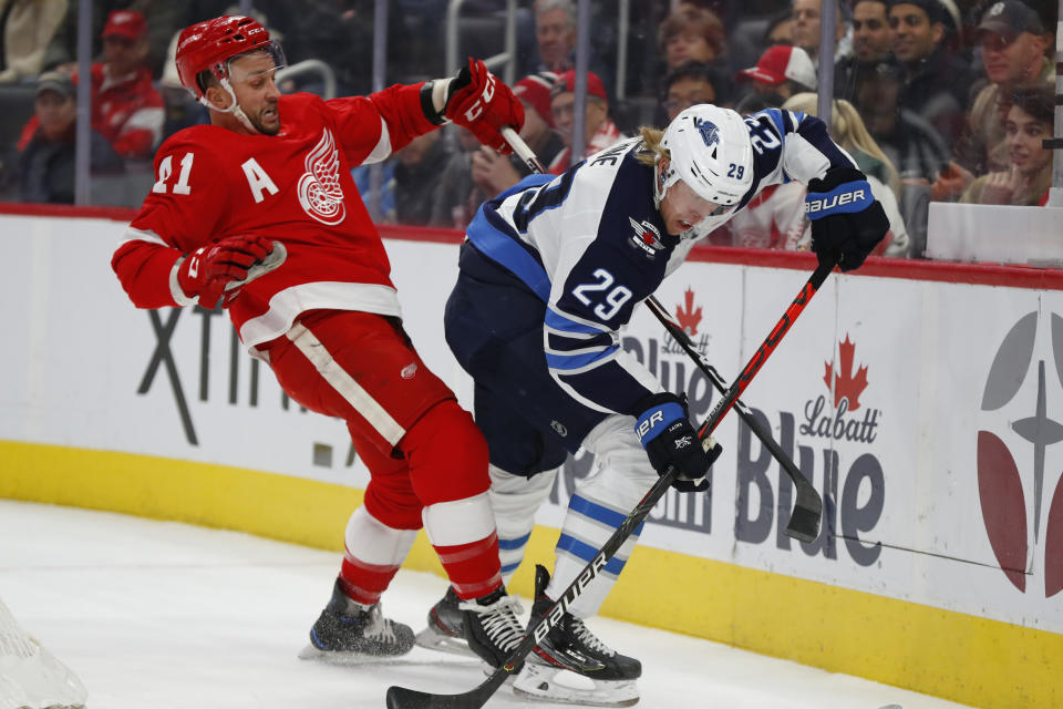 Winnipeg Jets right wing Patrik Laine (29) checks Detroit Red Wings center Luke Glendening (41) off the puck in the first period of an NHL hockey game Thursday, Dec. 12, 2019, in Detroit. (AP Photo/Paul Sancya)