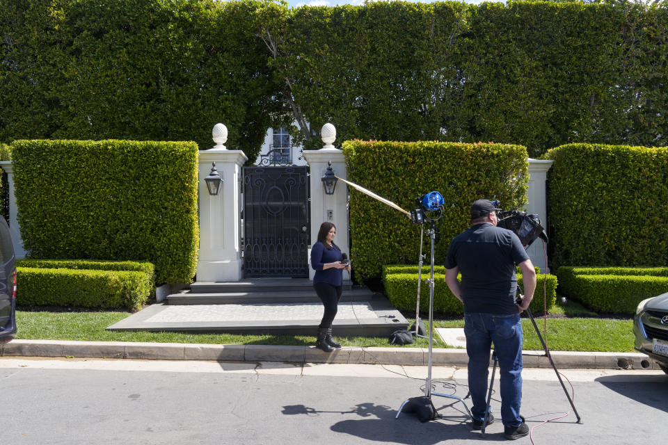 Television crews report live outside a property belonging to Sean "Diddy" Combs, Tuesday, March 26, 2024, in Los Angeles, the day after federal Homeland Security Investigations agents and other law enforcement executed a raid as part of an ongoing sex trafficking investigation by federal authorities in New York. (AP Photo/Damian Dovarganes)