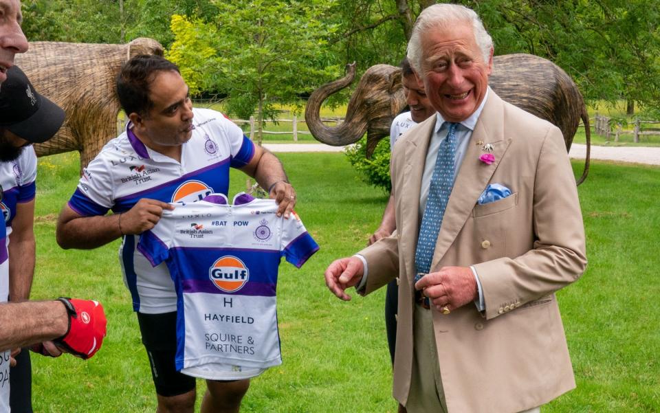 Prince Charles receives a cycling jersey from event organiser Rohit Chadda - Arthur Edwards - WPA Pool/Getty Images