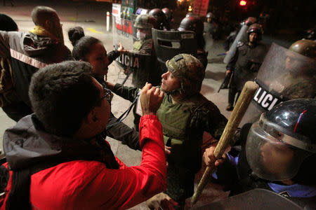 Supporters of Salvador Nasralla, presidential candidate for the Opposition Alliance Against the Dictatorship, argue with military police during a protest to demand the official presidential election results, outside the warehouse of the Supreme Electoral Tribunal in Tegucigalpa, Honduras November 30, 2017. REUTERS/Jorge Cabrera