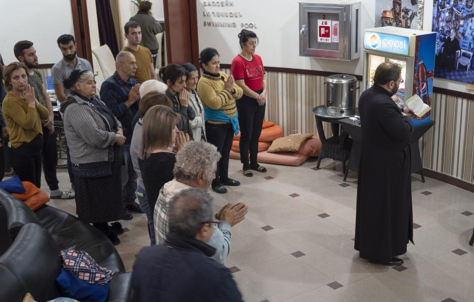 People pray in an improvised bomb shelter during a military conflict in Stepanakert, the separatist region of Nagorno-Karabakh, Monday, Oct. 12, 2020. Armenia and Azerbaijan have accused each other of attacks over the separatist territory of Nagorno-Karabakh despite a cease-fire deal brokered by Russia in an effort to end the worst outbreak of hostilities in decades. (AP Photo)