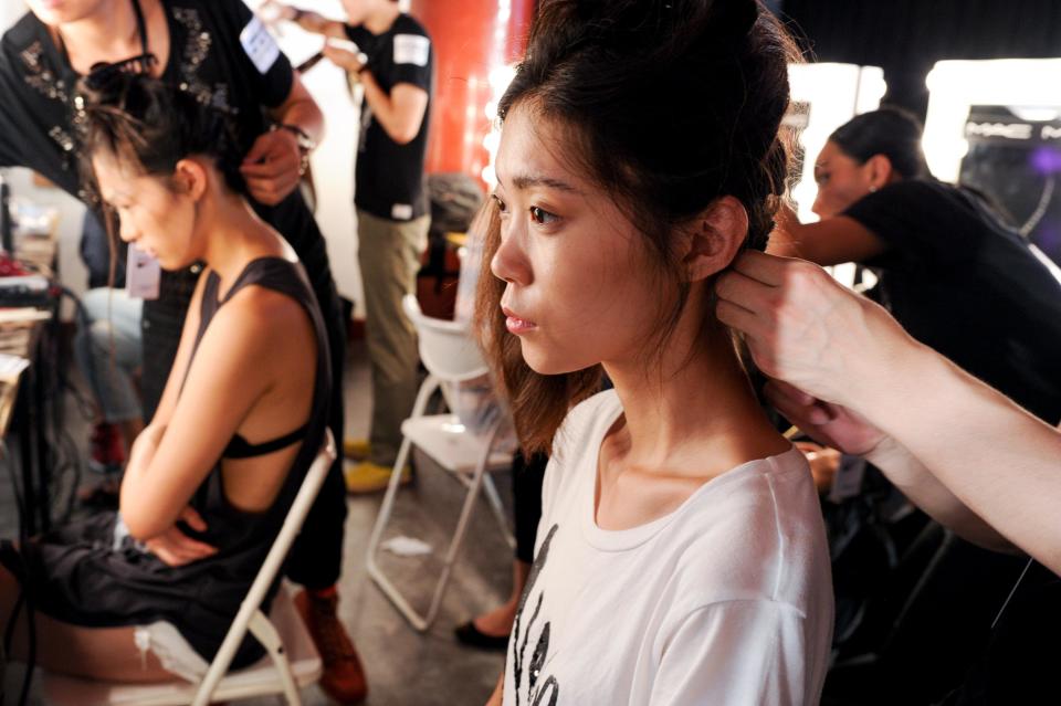 This June 2013 photo released by the Council of Fashion Designers of America (CFDA) shows models being prepared for a fashion show by New York-based designers in Beijing, China. Rag & Bone, Marchesa and Proenza Schouler, among the top in their class of cool, youngish New York-based fashion houses, took a field trip to China recently to introduce themselves to Chinese consumers and to bring home a better understanding of their needs. (AP Photo/Council of Fashion Designers of America, Neil Rasmus)