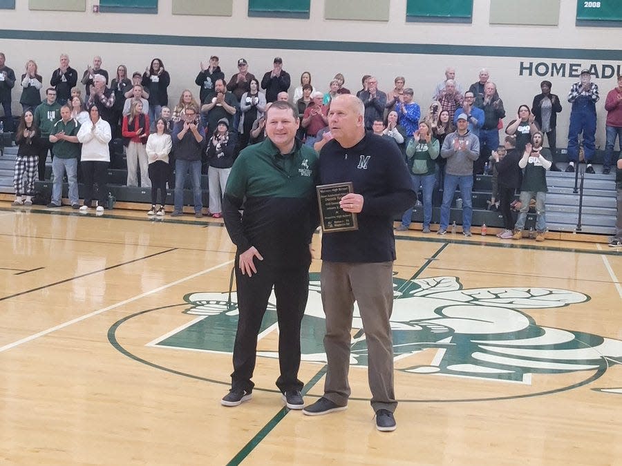 Brown Local Schools Superintendent Mark Scott presents a plaque to Malvern boys basketball coach Dennis Tucci in honor of his 600th career win prior to Friday's game against Newcomerstown. Tucci won his 600th game last week at Maysville.