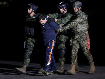 Recaptured drug lord Joaquin "El Chapo" Guzman is escorted by soldiers at the hangar belonging to the office of the Attorney General in Mexico City, Mexico January 8, 2016. REUTERS/Henry Romero