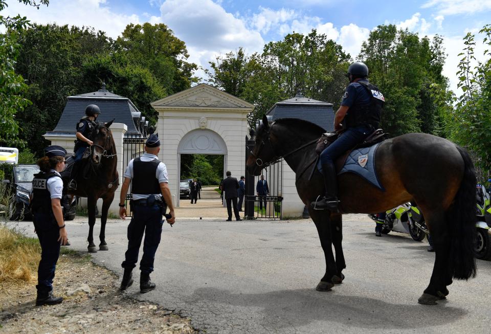 French police officers and mounted police stand guard outside the gated entrance of the Chateau Louis XIV belonging to Saudi Crown Prince Mohammed bin Salman, in Louveciennes outside Paris on July 28, 2022.  / Credit: JULIEN DE ROSA/AFP via Getty Images