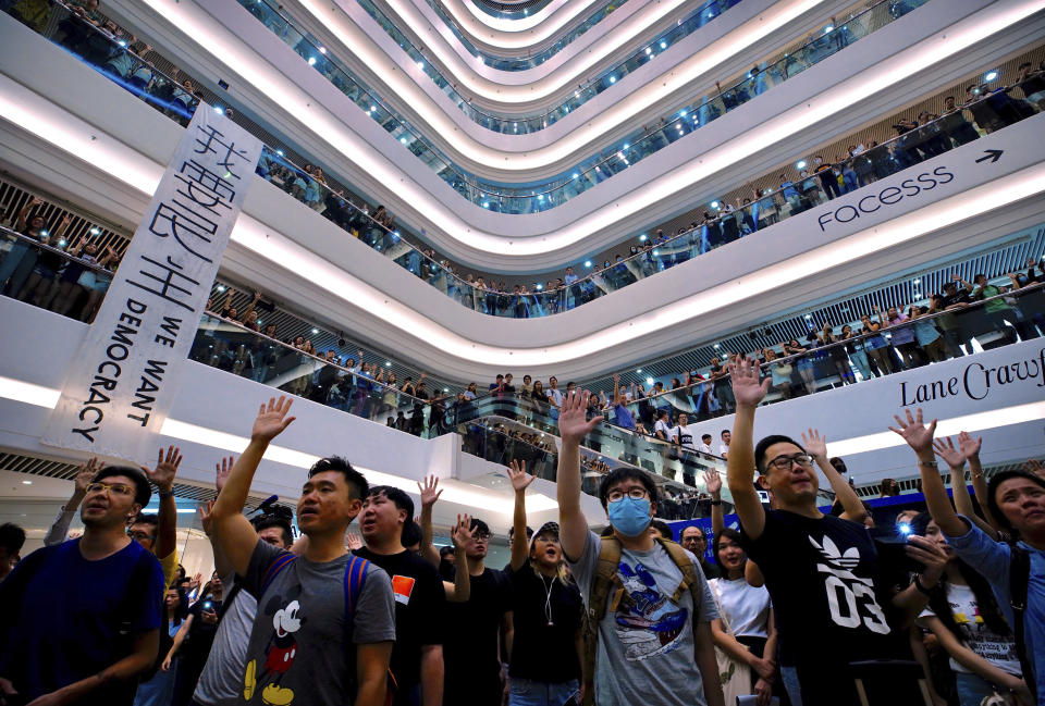 Demonstrators sing a theme song written by protestors "Glory to Hong Kong" at the Times Square shopping mall in Hong Kong, Thursday, Sept. 12, 2019. Thousands of people belted out a new protest song at Hong Kong's shopping malls in an act of resistance that highlighted the creativity of demonstrators in their months-long fight for democratic freedoms in the semi-autonomous Chinese territory. (AP Photo/Vincent Yu)