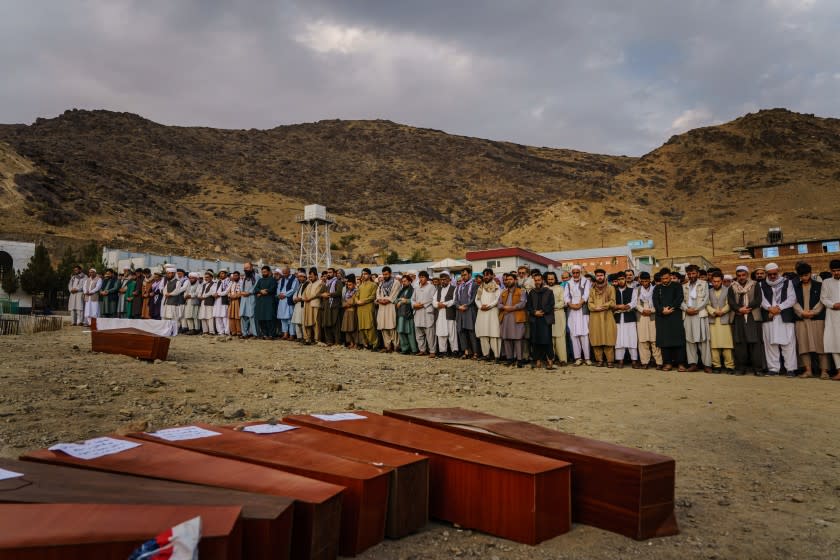 KABUL, AFGHANISTAN -- AUGUST 30, 2021: Islamic prayers are recited for the dead before they could be laid into the ground to be buried, as around 200 people attend a mass funeral for the 10 civilians killed by a U.S. drone strike said to be targeting ISIS-K militants, in Kabul, Afghanistan, Monday, Aug. 30, 2021. (MARCUS YAM / LOS ANGELES TIMES)